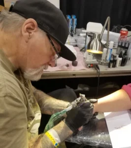 Lenda da tatuagem preto e cinza, o tatuador Jack Rudy trabalhando