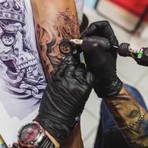 Homem fazendo uma tatuagem no braço